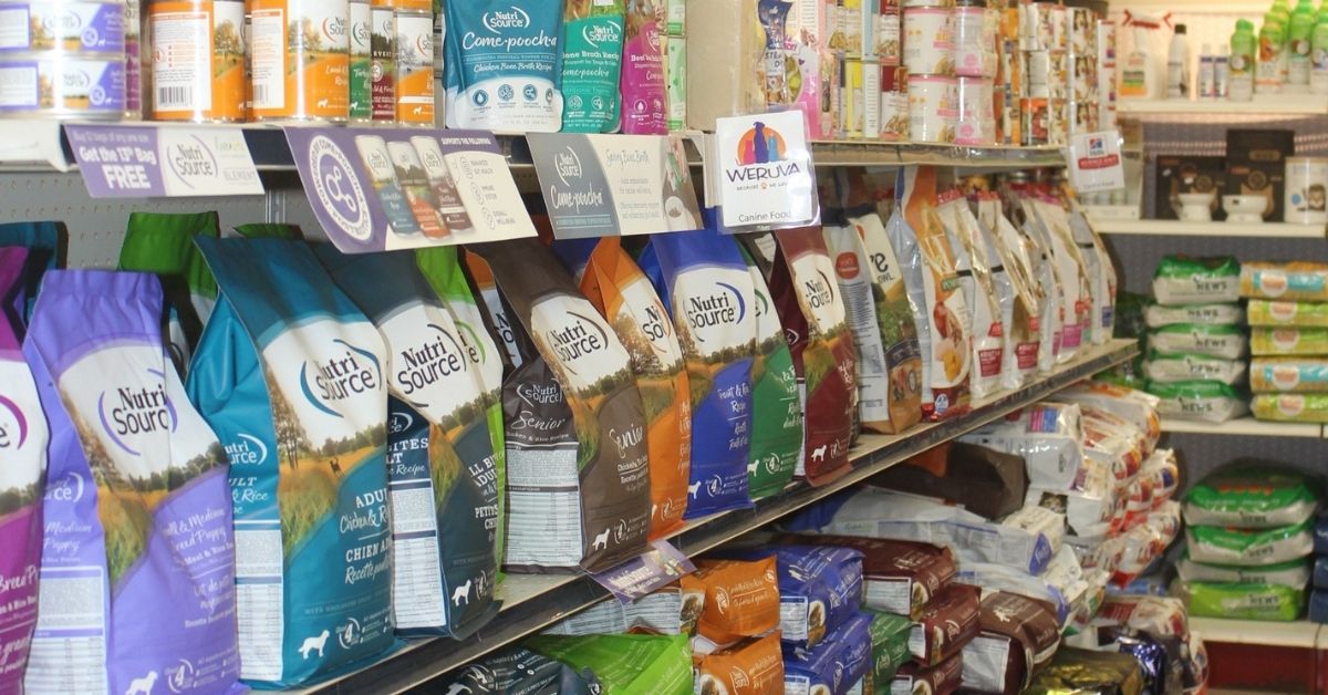 A grocery aisle stocked with rows of packaged pet food and treats